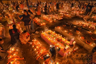 A diverse family gathering outdoors honoring ancestors with candles and smiles.