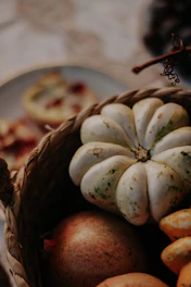 Stacked baskets filled with assorted gourds and squash, accented by warm autumn leaves.