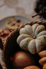 Stacked baskets filled with assorted gourds and squash, accented by warm autumn leaves.