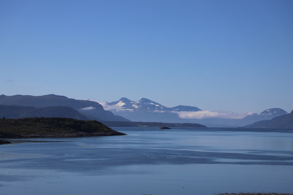 a body of water with mountains in the background