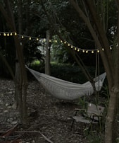 A peaceful garden nook with a hammock and soft fairy lights glowing at dusk.