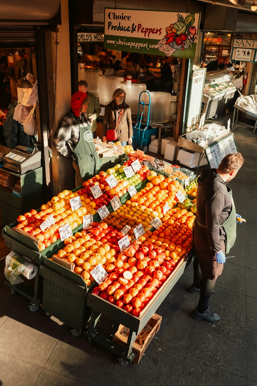 a person stands next to a fruit stand