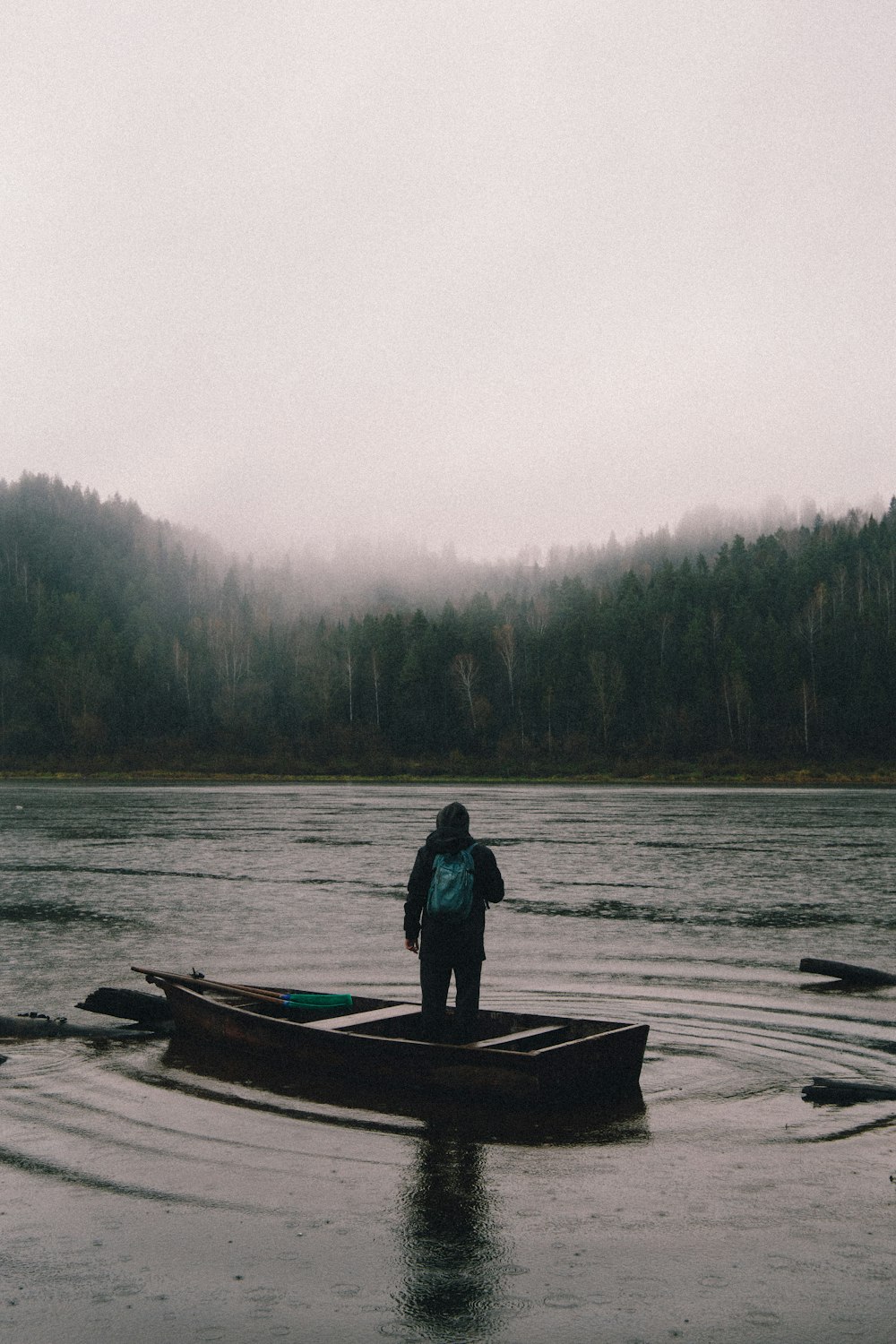 a person standing on a boat in a lake