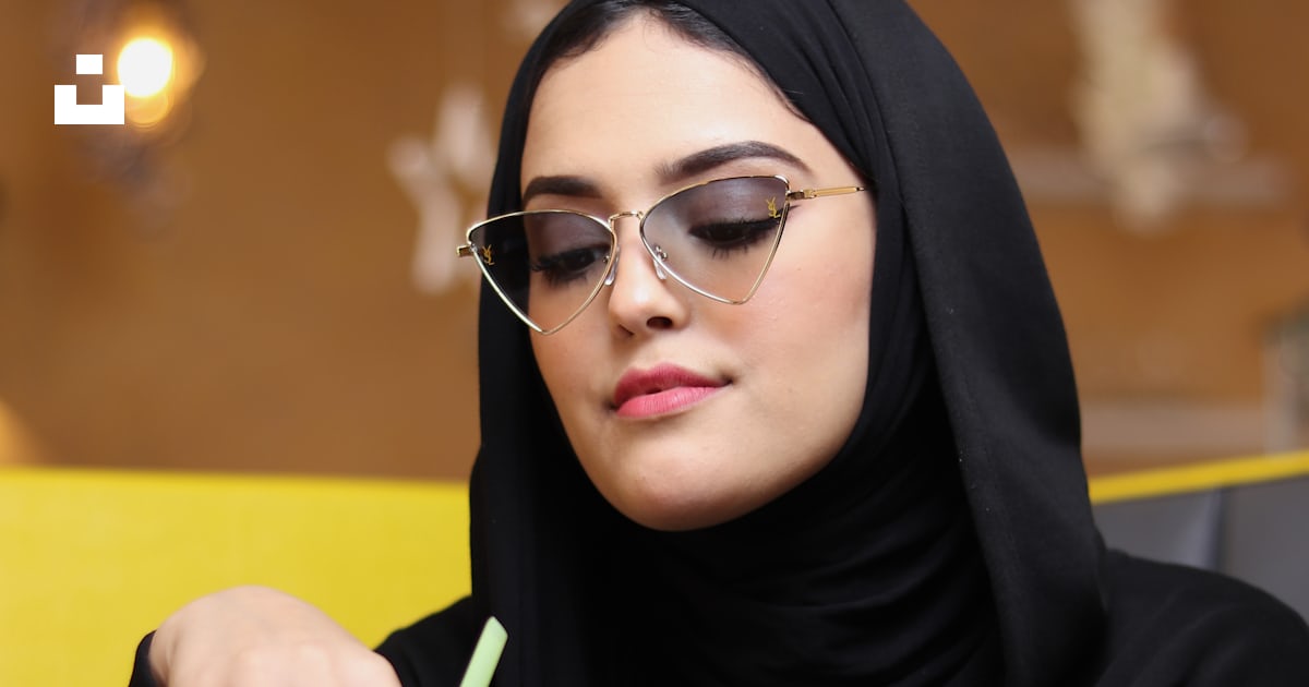 A Person Wearing A Black Head Scarf And Holding A Red Can Photo Free a-person-wearing-a-black-head-scarf-and-holding-a-red-can-photo-free