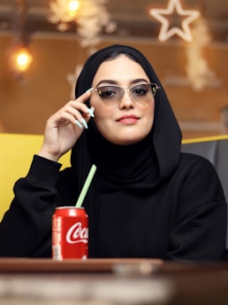 a woman wearing a black head scarf and holding a cigarette