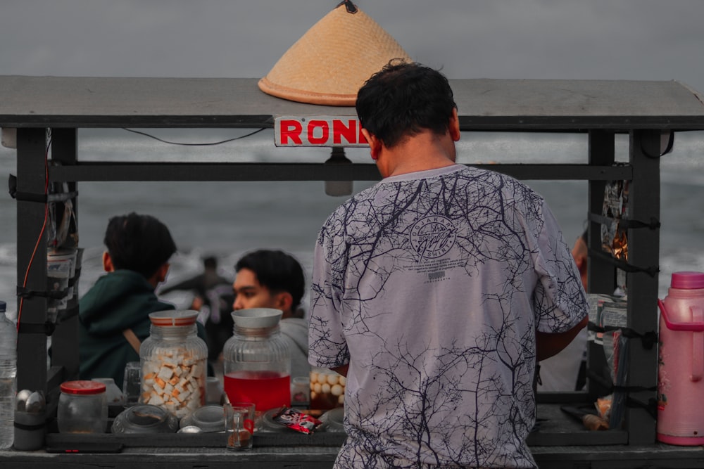 a man standing in front of a food stand