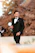 A smiling man wearing a sleek formal vest from Vesper Press, standing confidently outdoors.
