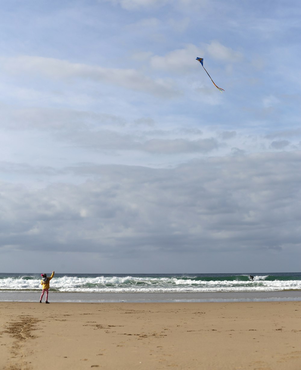 a person flying a kite on the beach