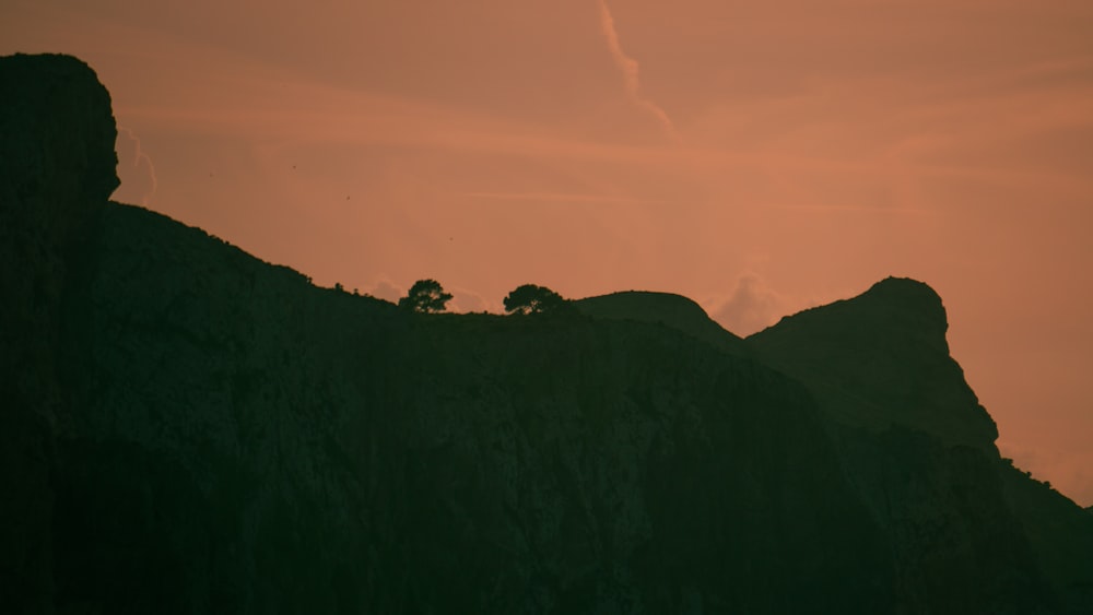 a silhouette of a person on a hill