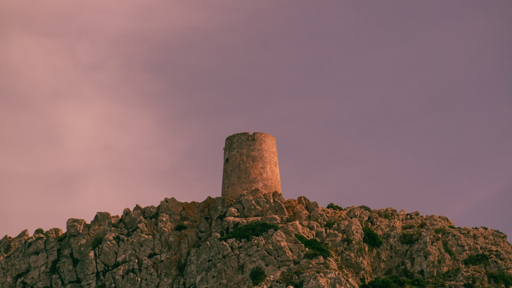 Una torre de piedra en una colina rocosa