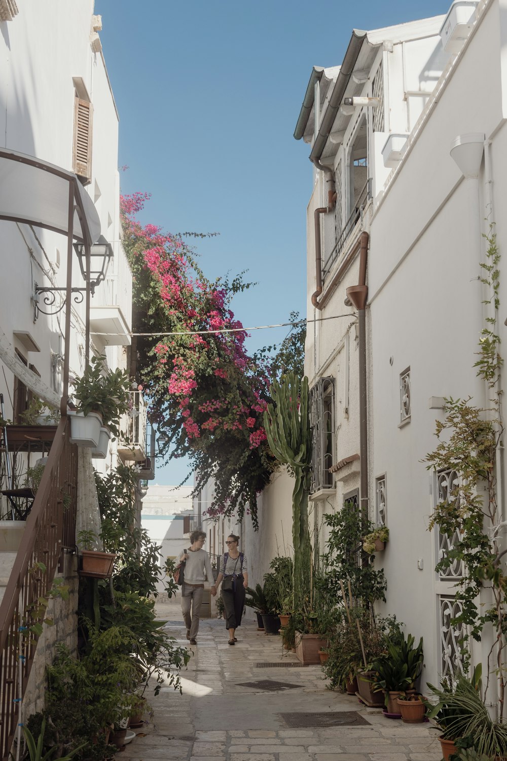 Una pareja caminando por una calle estrecha