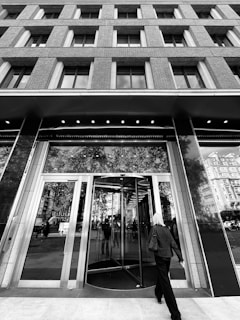 A sleek, glass office entrance with a person seamlessly walking through as smart sensors activate the door.