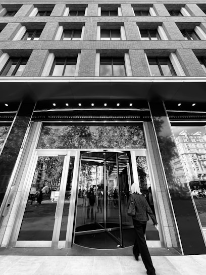 A sleek, glass office entrance with a person seamlessly walking through as smart sensors activate the door.