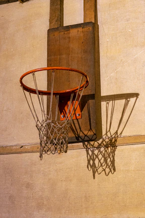 A vintage leather basketball spinning on a wooden gym floor with blurred background.