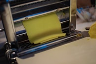 Modern machinery shaping stainless steel sheets into cookware components.