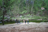 A team of environmental specialists analyzing data outdoors near a river.