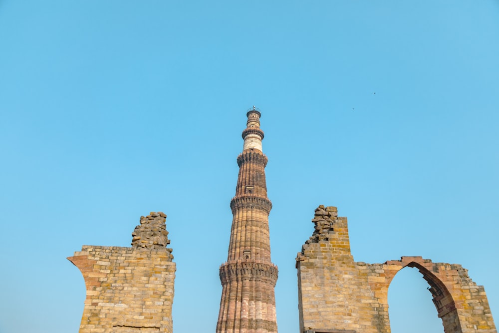 a group of tall towers with Qutub Minar in the background