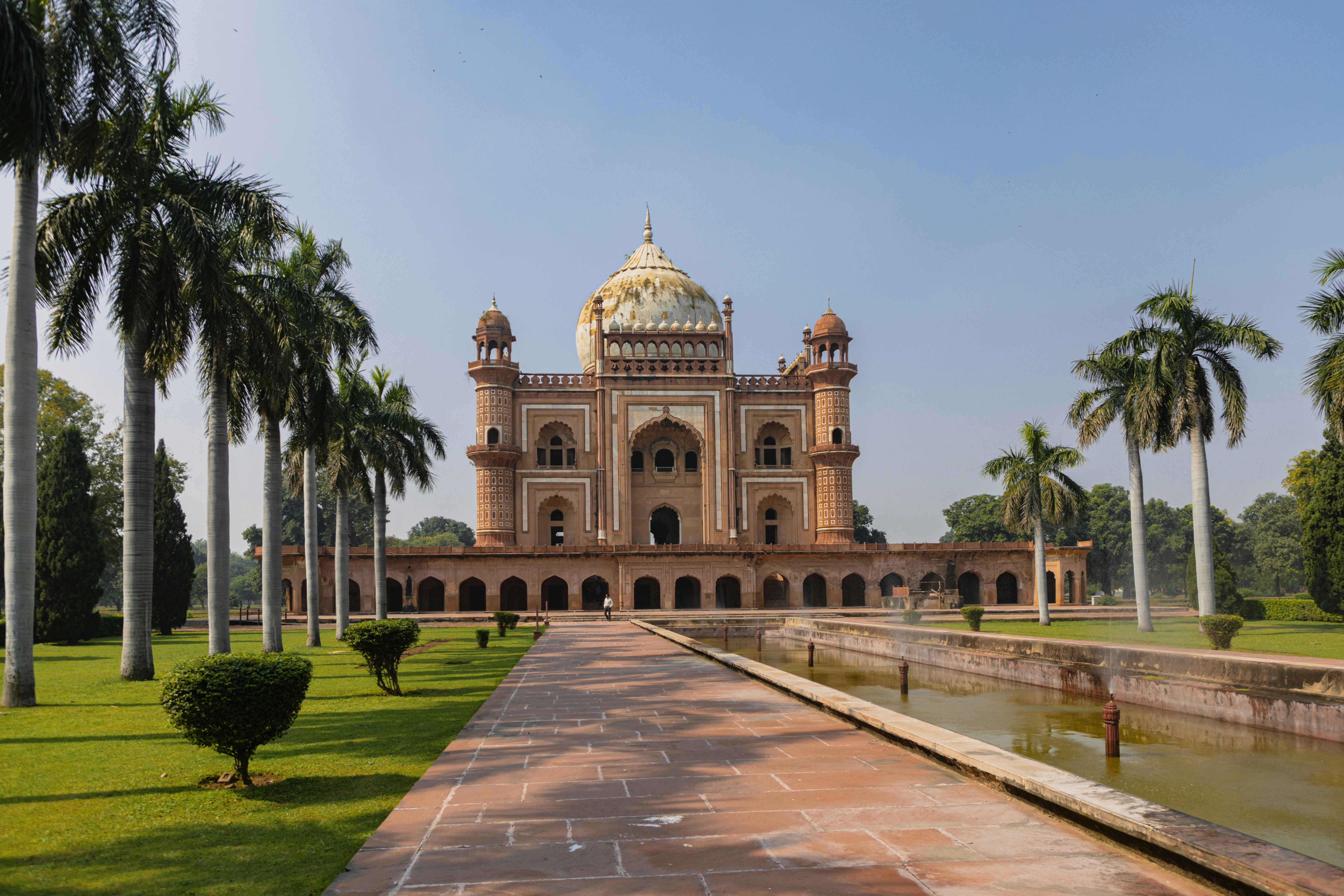 a large building with a dome and palm trees in front of it
