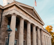 a building with columns and a flag on top