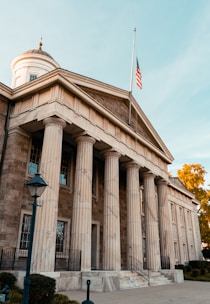 a building with columns and a flag on top