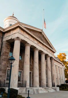 a building with columns and a flag on top