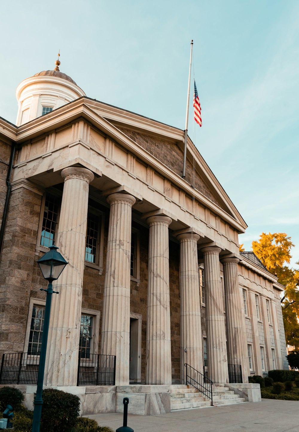 a building with columns and a flag on top