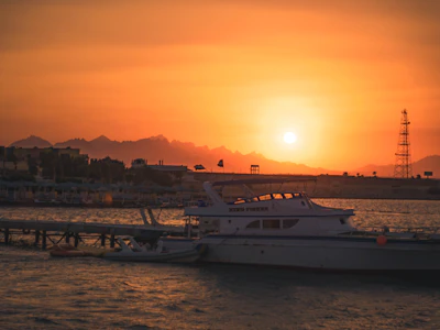 Boats moored at the Red Sea shore in Hurghada as the sun sets behind the desert hills