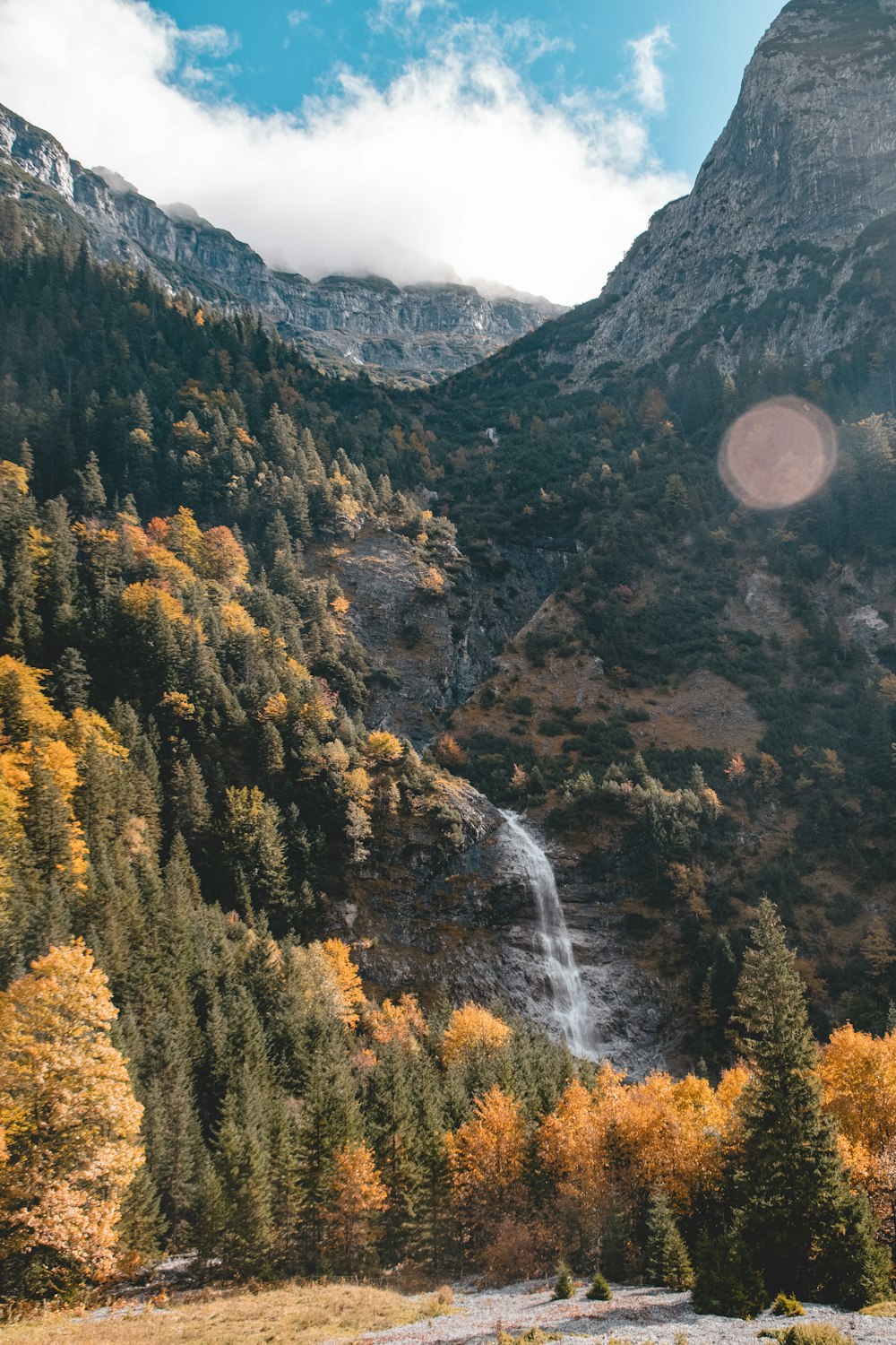 a waterfall in a valley between mountains