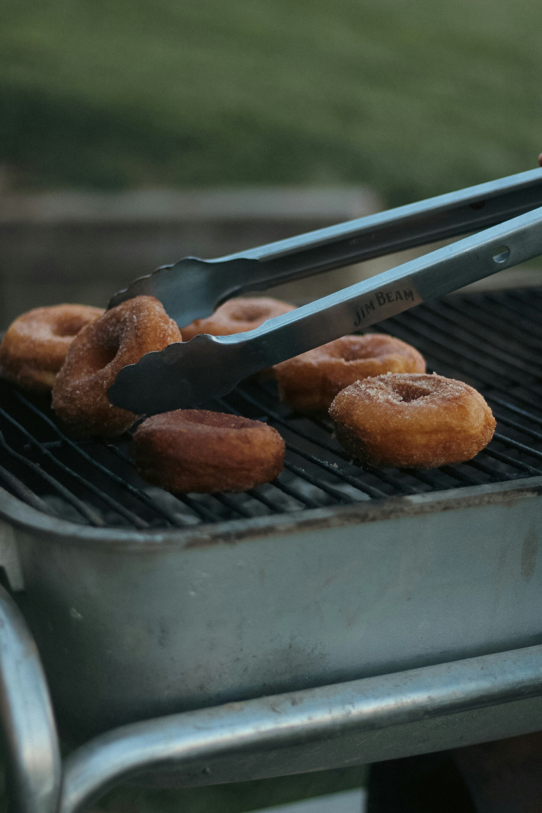 une personne met des beignets dans un gril