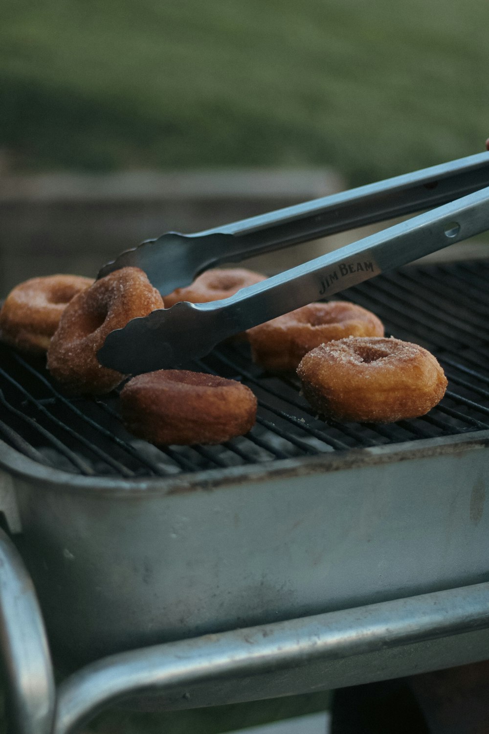 a person is putting donuts in a grill