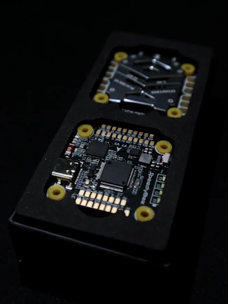 Close-up of a multi-layer PCB alongside an assembled embedded device with sleek enclosure.
