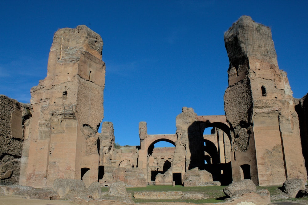 a stone building with a few archways with Baths of Caracalla in the background