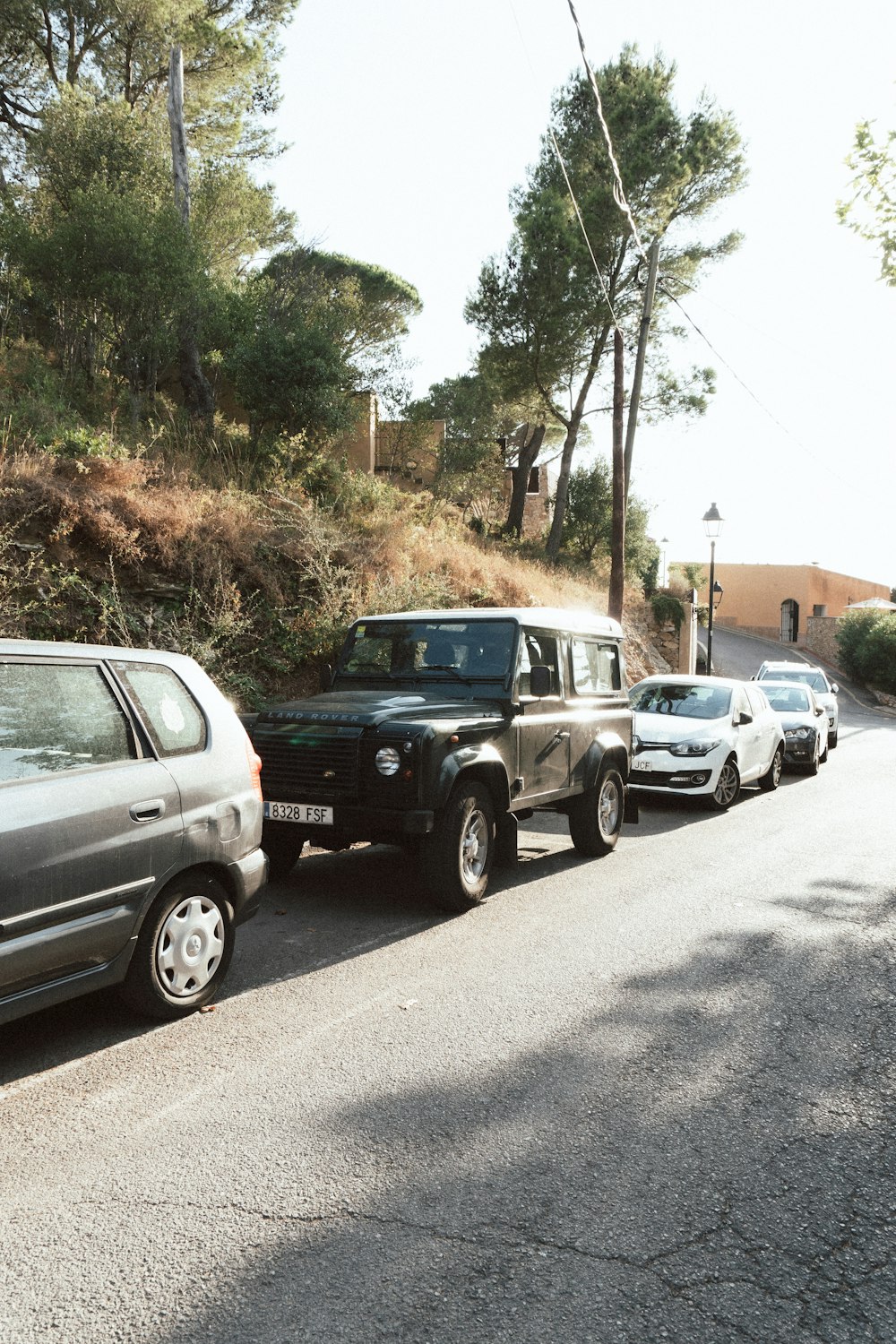 Un grupo de autos estacionados al costado de una carretera