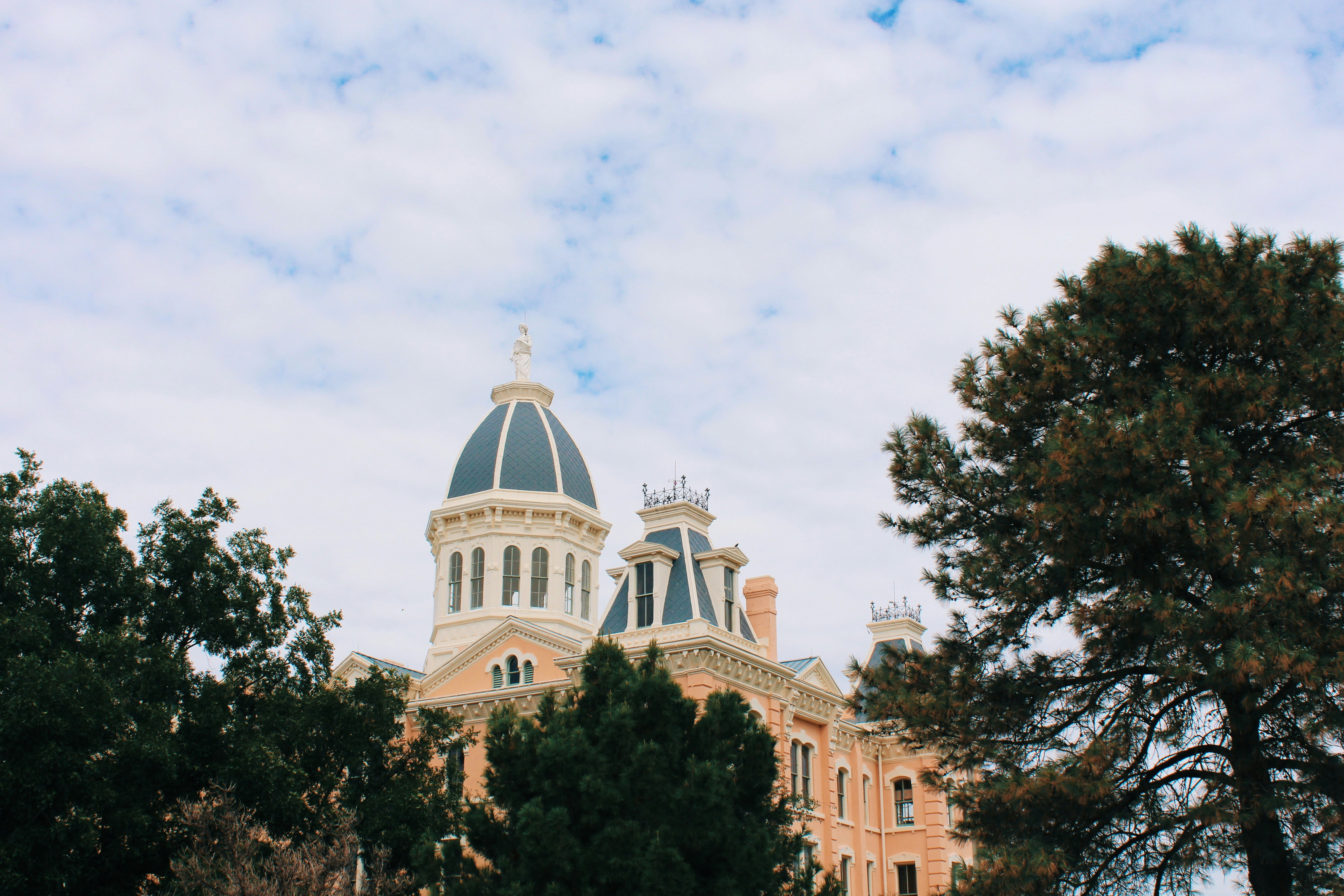 ein Gebäude mit einer Kuppel und Bäumen davor