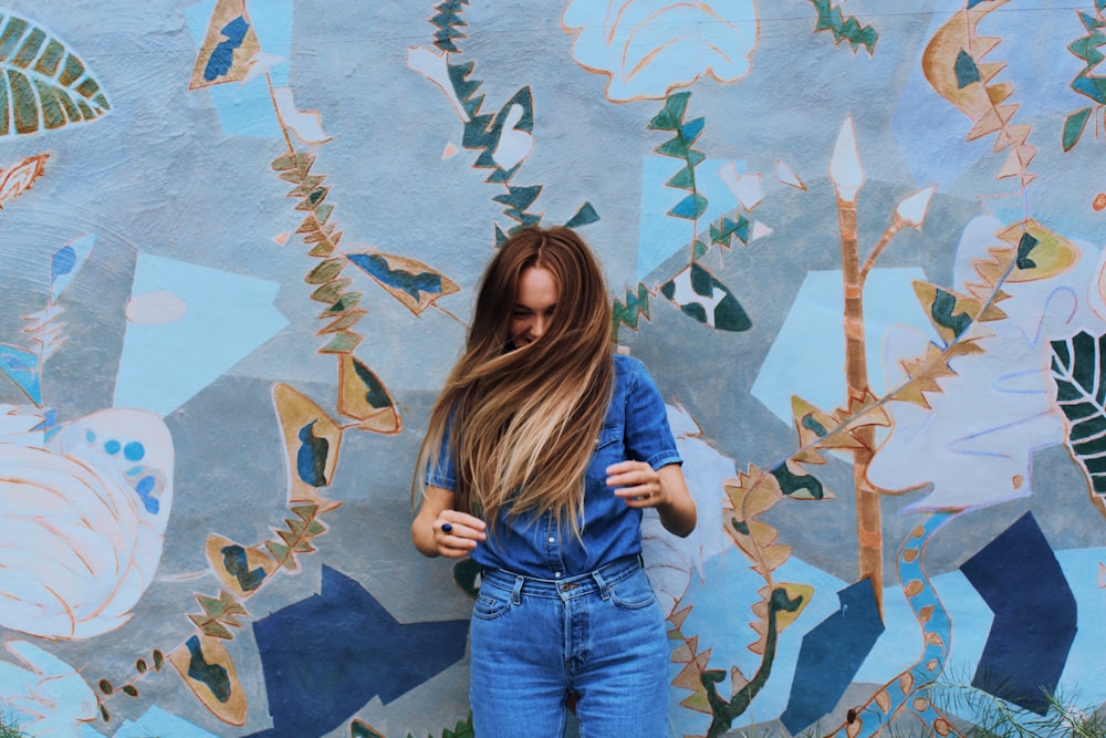 a person standing in front of a wall with butterflies