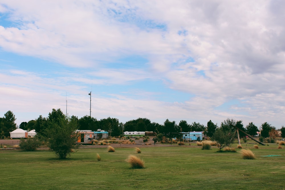 a field of grass with bales of hay in it