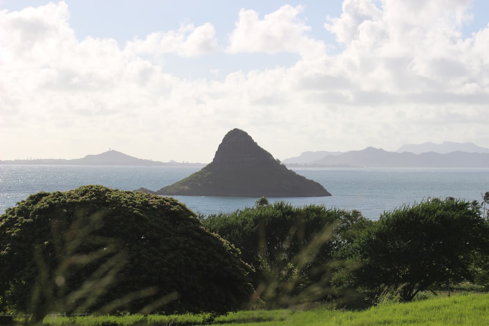 a group of large rocks in the water with Pitons in the background