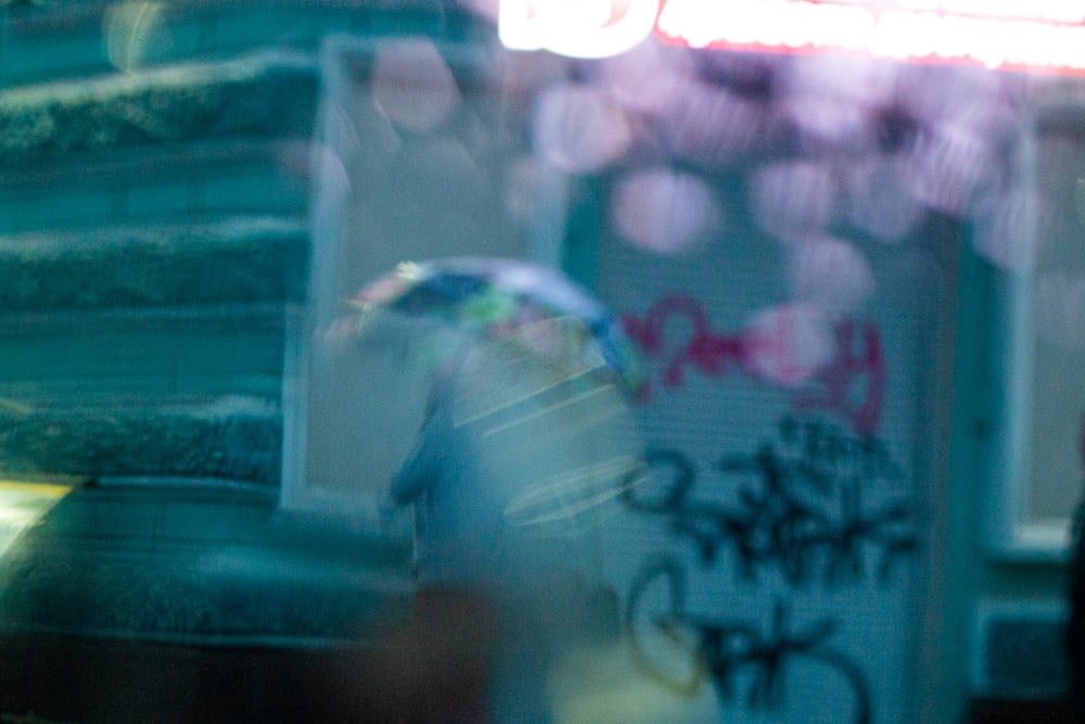 a blurry image of a person walking with an umbrella