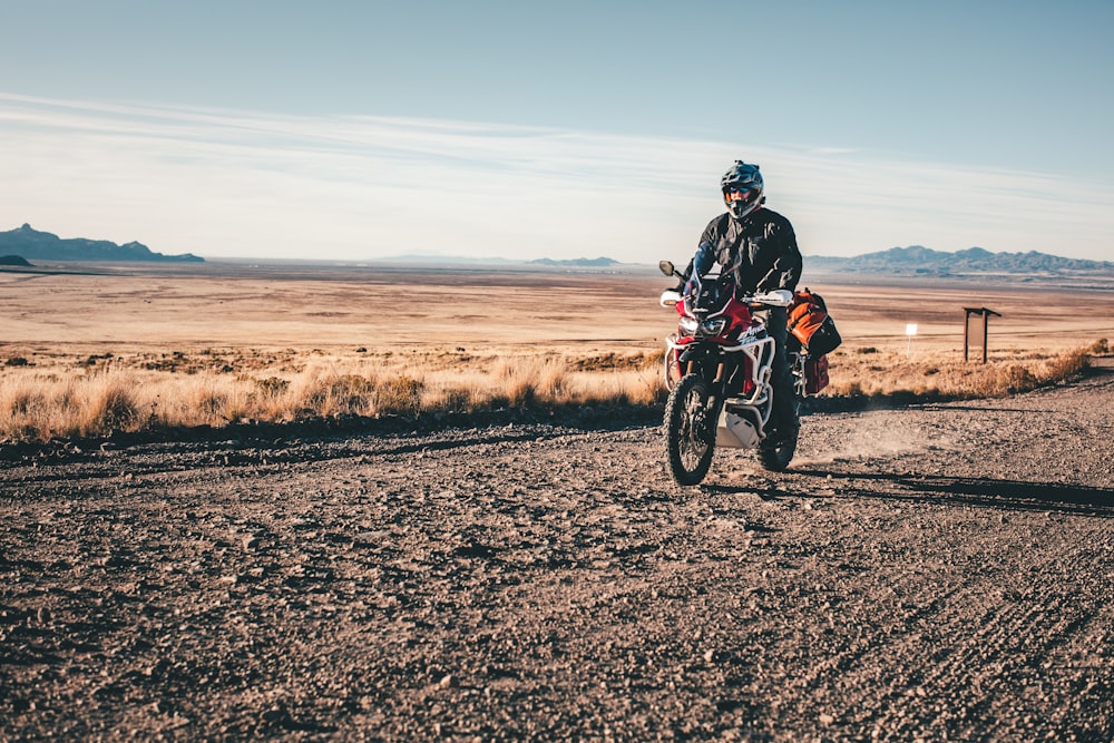 a man riding a motorcycle on a dirt road