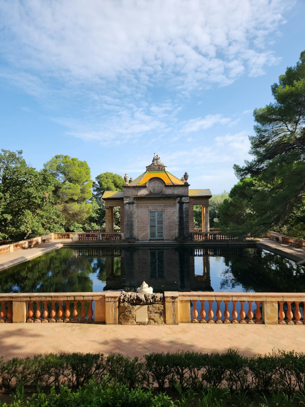 a building with a gold roof and a gold roof by a pond