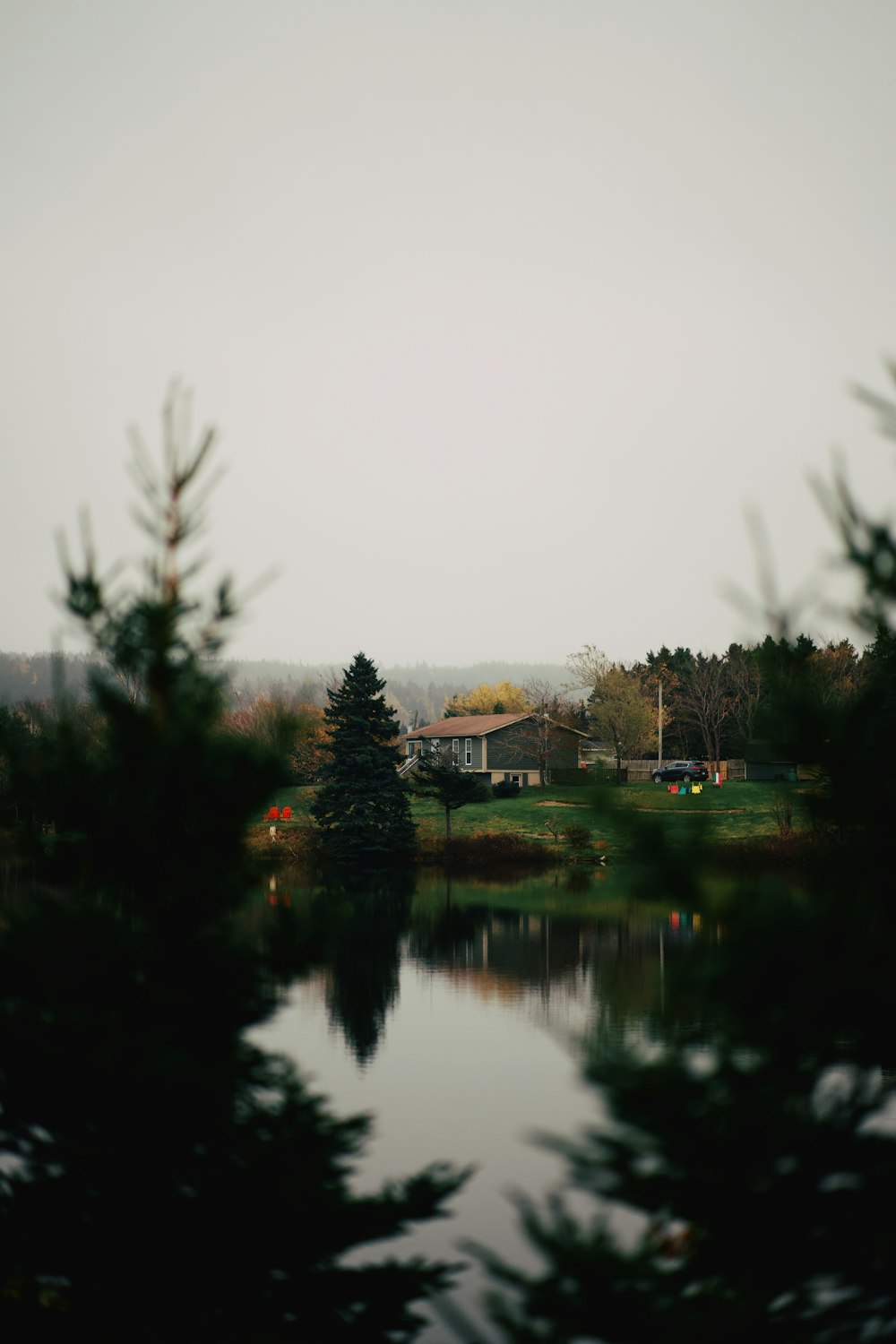 a body of water with trees and a house in the background