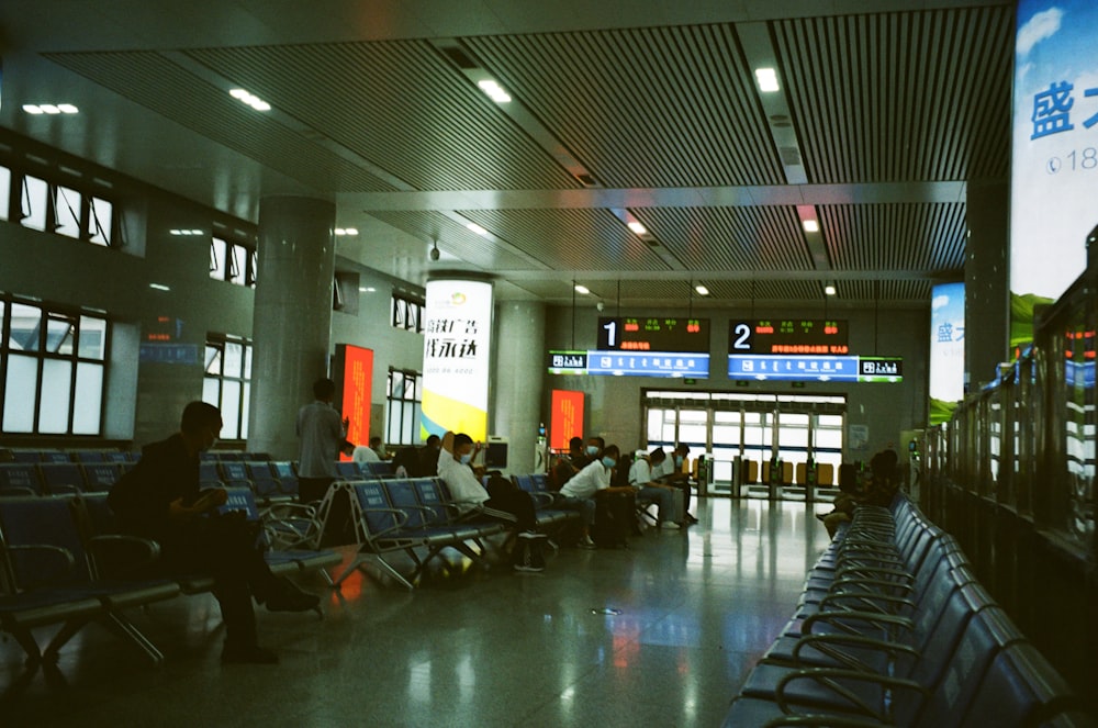 a group of people sitting in a large room with a large screen