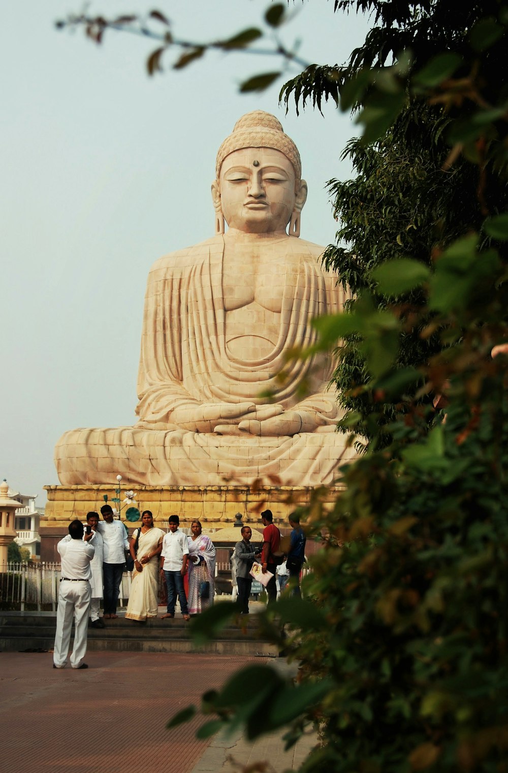 a group of people standing next to a large statue