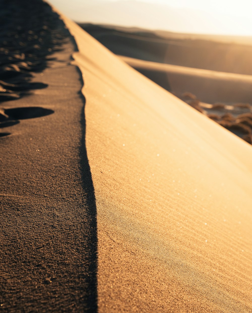 a sandy beach with a body of water in the background