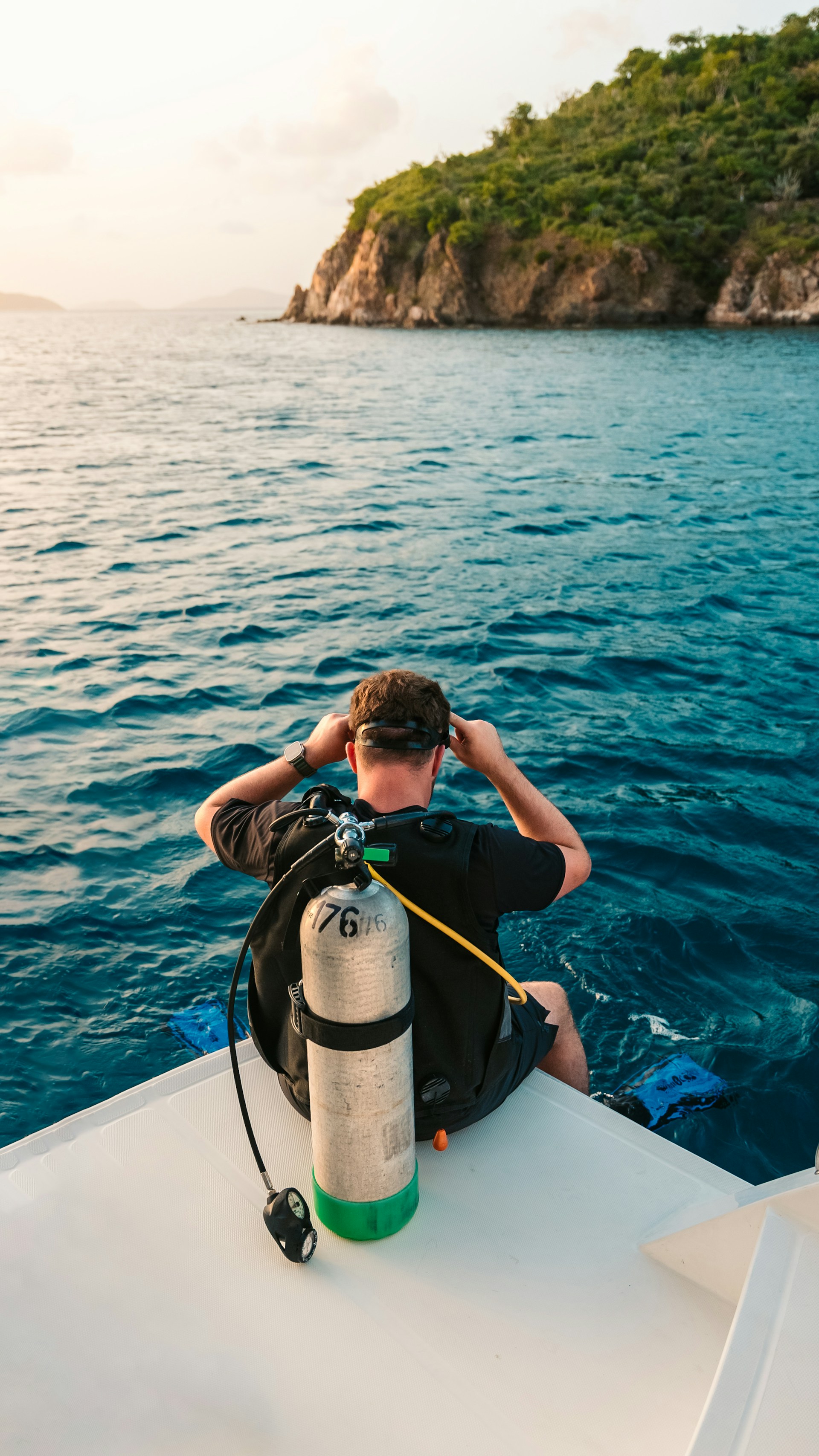 A beginner diver receiving friendly guidance from an instructor on the boat, with the sparkling Red Sea in the background.