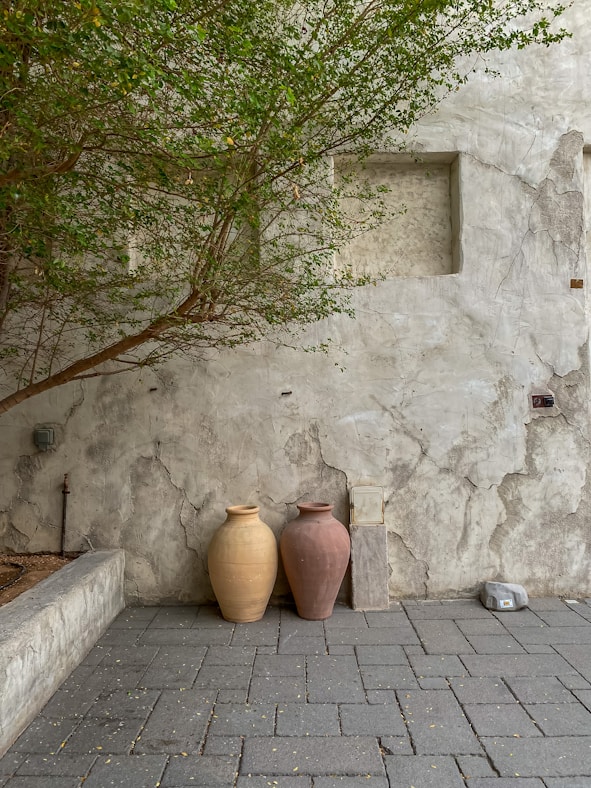 a couple of vases sit on a brick surface