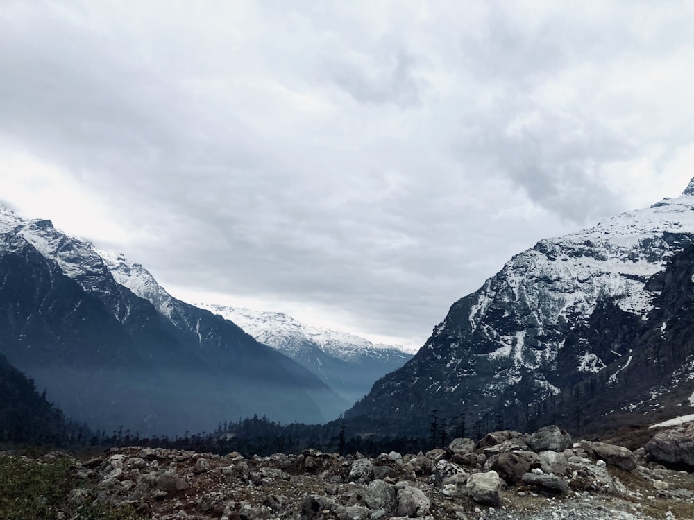 a rocky area with mountains in the back