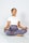 A person is meditating cross-legged on a yoga mat, wearing a white t-shirt and grey leggings, with eyes closed and in a calm posture.