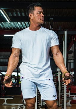 A muscular man mid-air during a box jump, veins prominent, sweat glistening under gym lights.