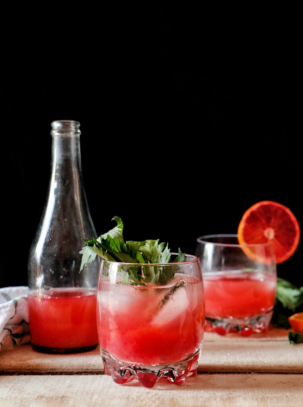 a glass bottle and a glass with liquid in it